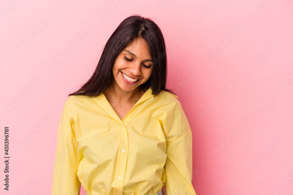Young latin woman isolated on pink background laughs and closes eyes, feels relaxed and happy. Young latin woman isolated on pink background laughs and closes eyes, feels relaxed and happy.