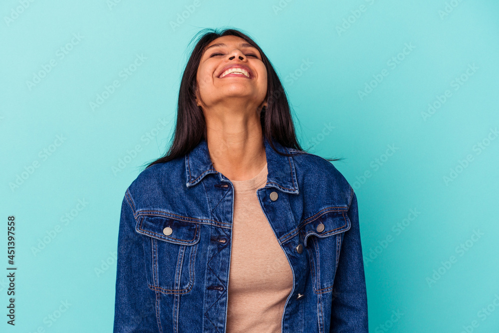 © Asier - Young latin woman isolated on blue background relaxed and happy laughing, neck stretched showing teeth.