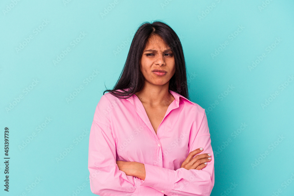 Young latin woman isolated on blue background tired of a repetitive task. Young latin woman isolated on blue background tired of a repetitive task.
