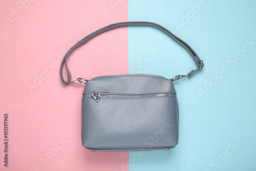 Fashionable leather bag on pink blue pastel background. Top view