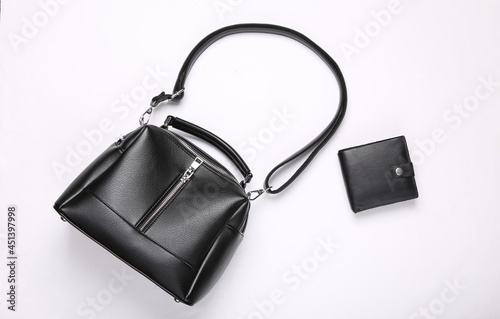 Fashionable leather black bag and purse on white background. Top view. Flat lay