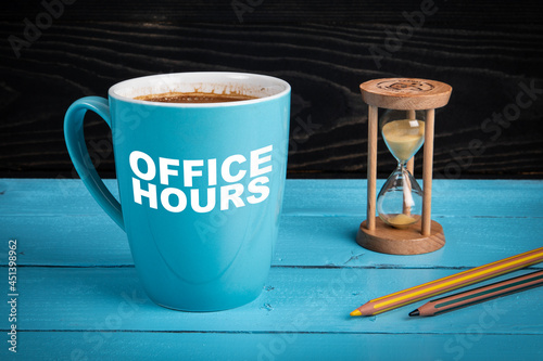Office Hours. Coffee mug, hourglass and pencils on the office desk