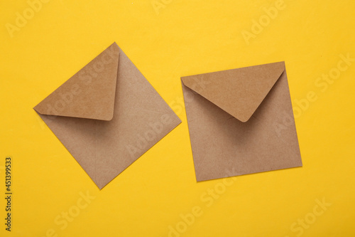 Craft envelopes on yellow background. Top view