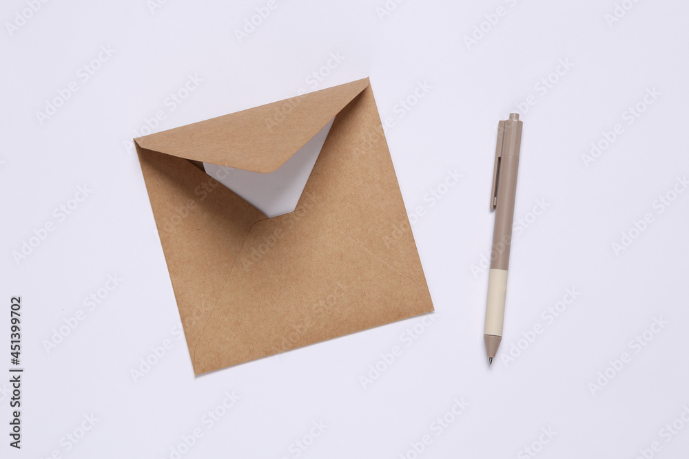 Craft envelope with letter and pen on white background. Top view Craft envelope with letter and pen on white background. Top view