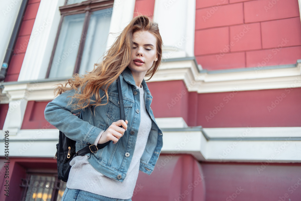 Stylish sexy woman in denim clothes and backpack in city Stylish sexy woman in denim clothes and backpack in city