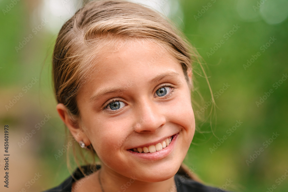 Portrait of a little girl with blue eyes a natural green background Portrait of a little girl with blue eyes a natural green background
