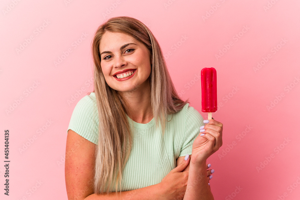 Young russian woman holding an ice cream isolated on pink background laughing and having fun. Young russian woman holding an ice cream isolated on pink background laughing and having fun.