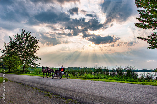 Amish Buggy at Sunset with sunbeams and clouds