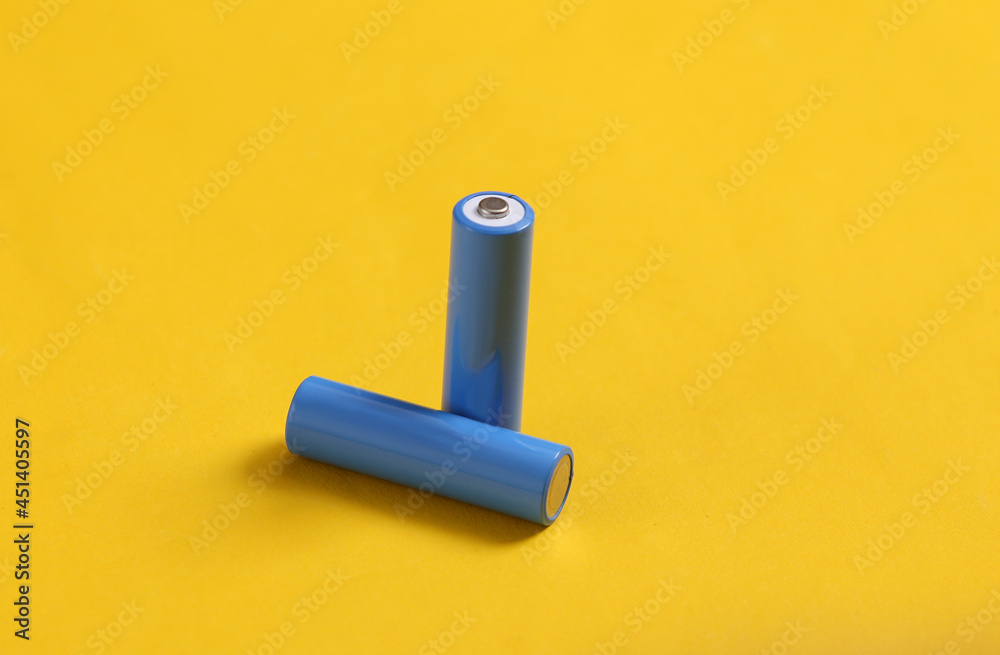 AA batteries on yellow background. Minimalism AA batteries on yellow background. Minimalism