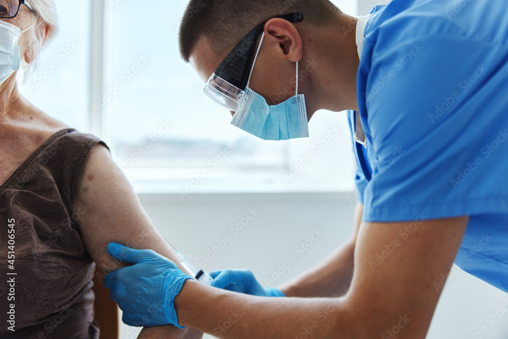 Obraz premium male doctor giving an injection covid-19 passport in medical masks