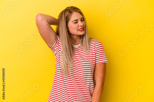 Young russian woman isolated on yellow background suffering neck pain due to sedentary lifestyle.