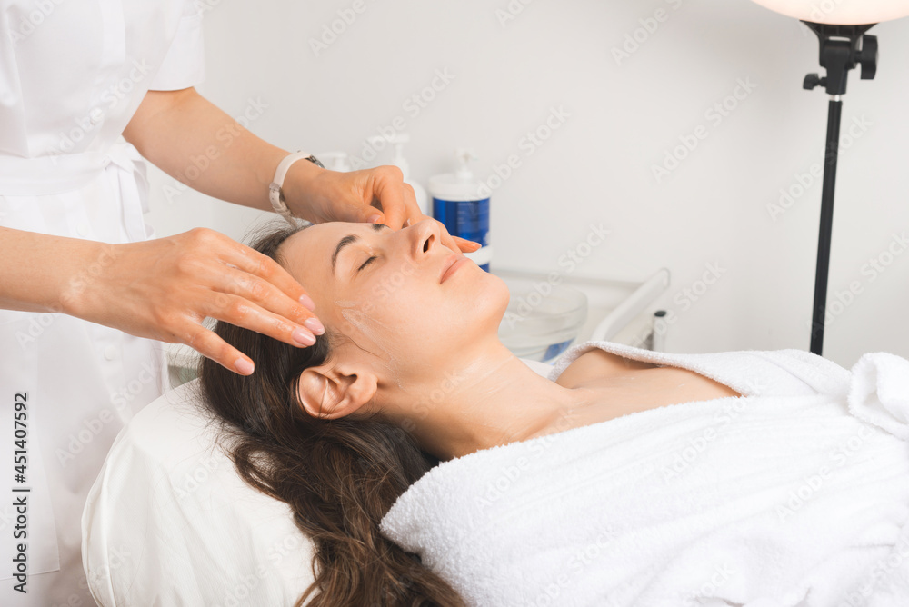 Face massage is the favorite part of the week, young woman is relaxing at the cosmetologist.