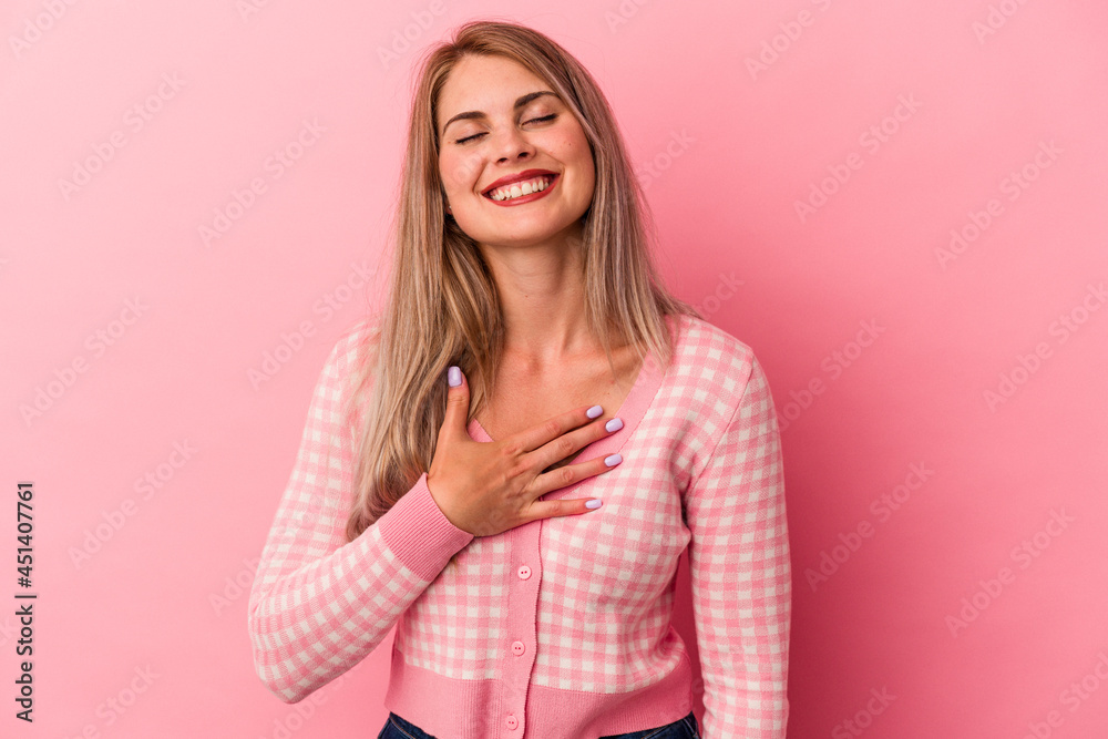 Young russian woman isolated on pink background laughs out loudly keeping hand on chest. Young russian woman isolated on pink background laughs out loudly keeping hand on chest.