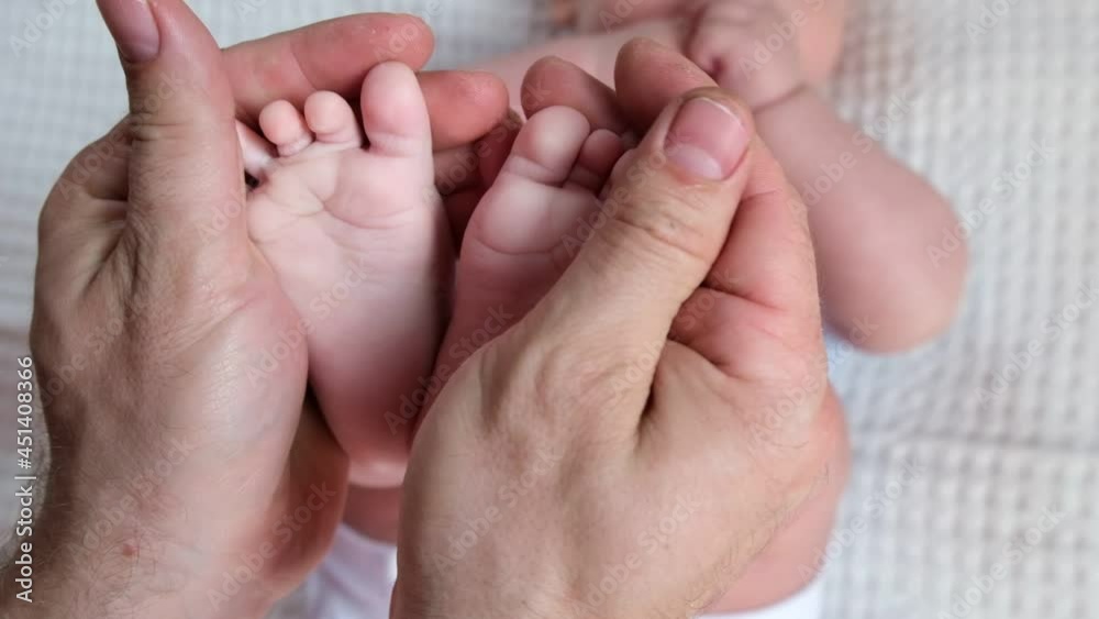 Father holding Baby Feet in Hands. Legs Newborn in male parents Hand. Small children's Feet in the Father's Palm. Close-up. Little Toes of Child and Man Hands of Happy Parent. Father's Day Holiday. Father holding Baby Feet in Hands. Legs Newborn in male parents Hand. Small children's Feet in the Father's Palm. Close-up. Little Toes of Child and Man Hands of Happy Parent. Father's Day Holiday.