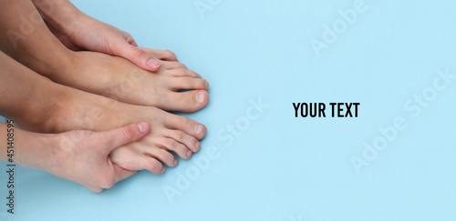 Fototapeta Naklejka Na Ścianę i Meble -  Female bare feet on blue background. Beauty Care Concept. Copy space