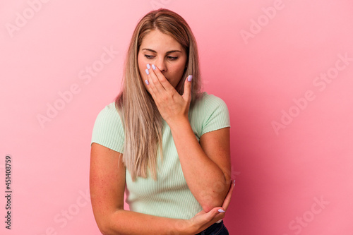 Young russian woman isolated on pink background yawning showing a tired gesture covering mouth with hand.