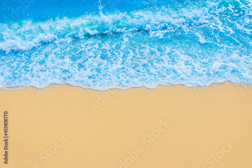 Blue seaside water on light yellow beach sand coastline seashore background