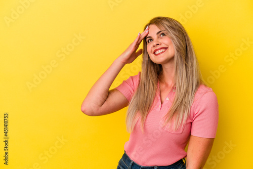 Young russian woman isolated on yellow background laughing happy, carefree, natural emotion.