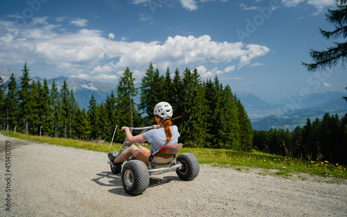 Riding a tricycle down a hill. Alpine meadow in the European Alps. During the summer guests can enjoy unique attractions. Tyrol that promote active recreation - including tricycles