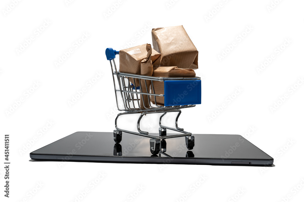 Shopping cart with boxes standing on a tablet illustrating shopping online from a pad. Isolated on white background.