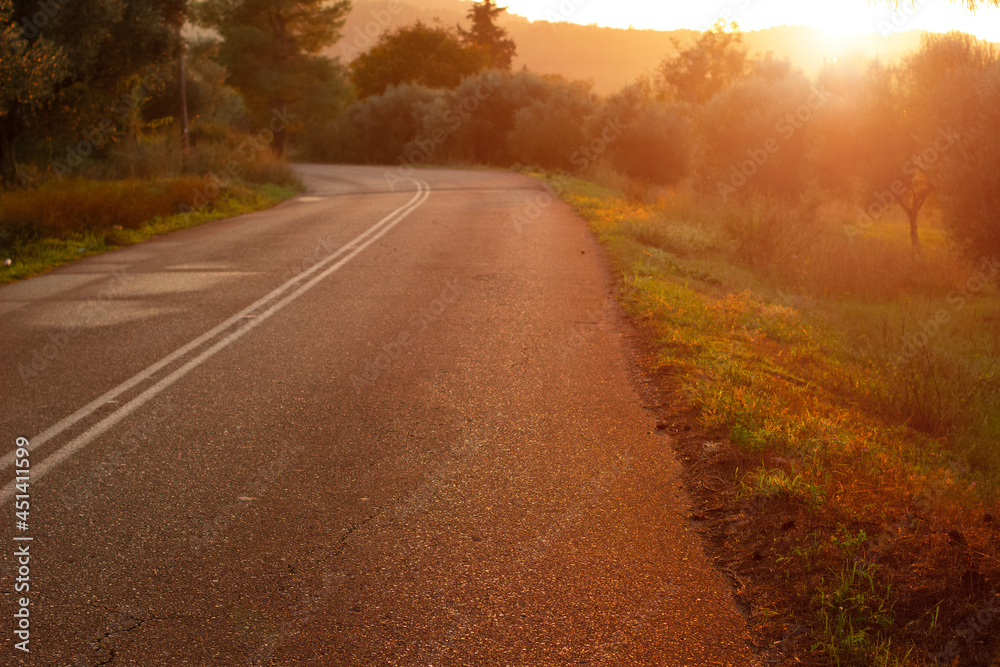 abandoned road country side environment solitude place in vibrant orange lighting of evening sunset