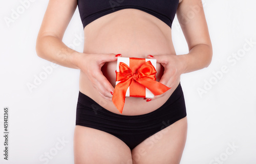 Wallpaper Mural A pregnant belly and a gift pregnant belly and a gift. Healthy pregnancy. Isolate on a white background Torontodigital.ca