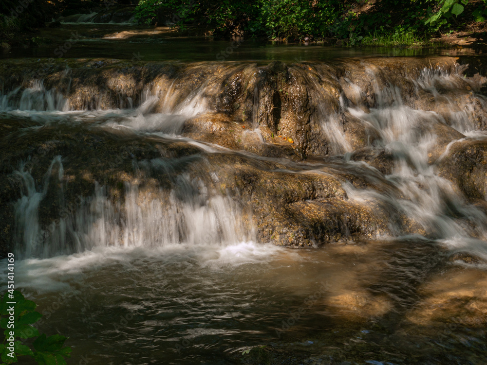 Fototapeta premium Klares Wasser fließt über den Felsen im Bach
