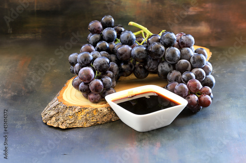 Grape molasses and fresh organic grapes photo