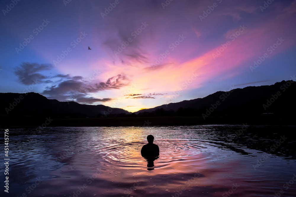 landscape silhouette The mountains, the sunset in the evening sky, and then the light hits the clouds is orange. There is a reflection in the river that feels relaxed There is space for text. landscape silhouette The mountains, the sunset in the evening sky, and then the light hits the clouds is orange. There is a reflection in the river that feels relaxed There is space for text.