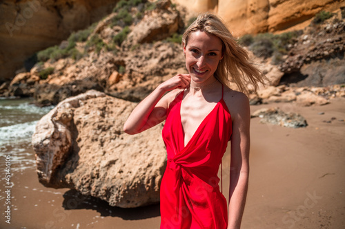 Charming happy woman in red dress on beach photo