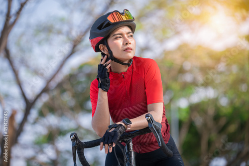 Portrait sport woman wearing sport suite helmet,glove and glasses,she competition on  bicycle bike is adventure and extream game concept.