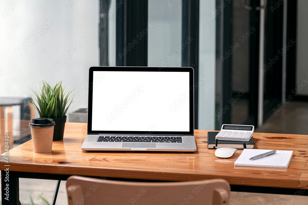 Mockup blank screen laptop computer and supplies on wooden table in modern office room. Mockup blank screen laptop computer and supplies on wooden table in modern office room.