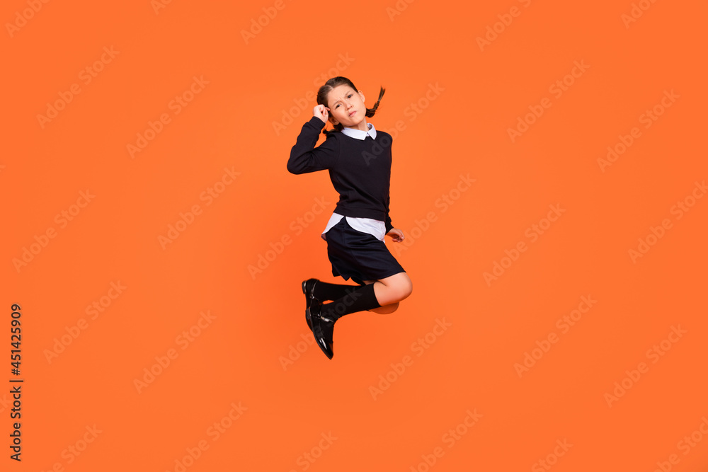 Full length body size view of attractive minded preteen girl jumping isolated over bright orange color background