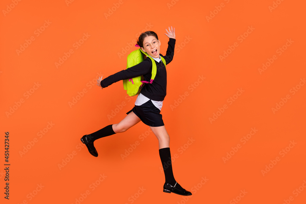 Full length profile side photo of young school girl happy positive smile jump run 1-september isolated over orange color background