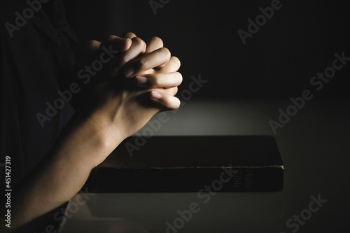 Women pray from god blessing to have a better life. Women hands praying to god with the bible. believe in goodness. Holding hands in prayer on a wooden table. Christian life crisis prayer to god.