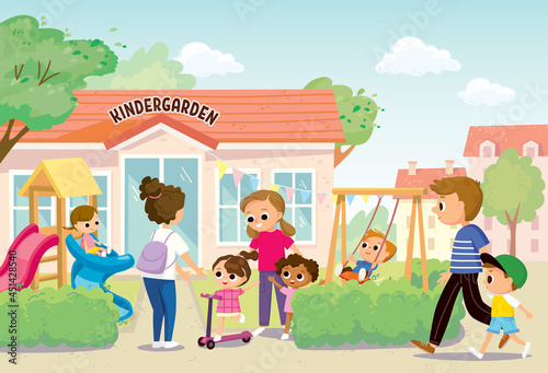 Young mother pick up her children kids from kindergarten or daycare center standing in front of playground of kindergarten building. Parents collect children after lessons in preschool on summer day