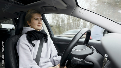 Young woman with natural look driving a passenger car on a German highway. The young woman shows various emotional reactions to the traffic event.