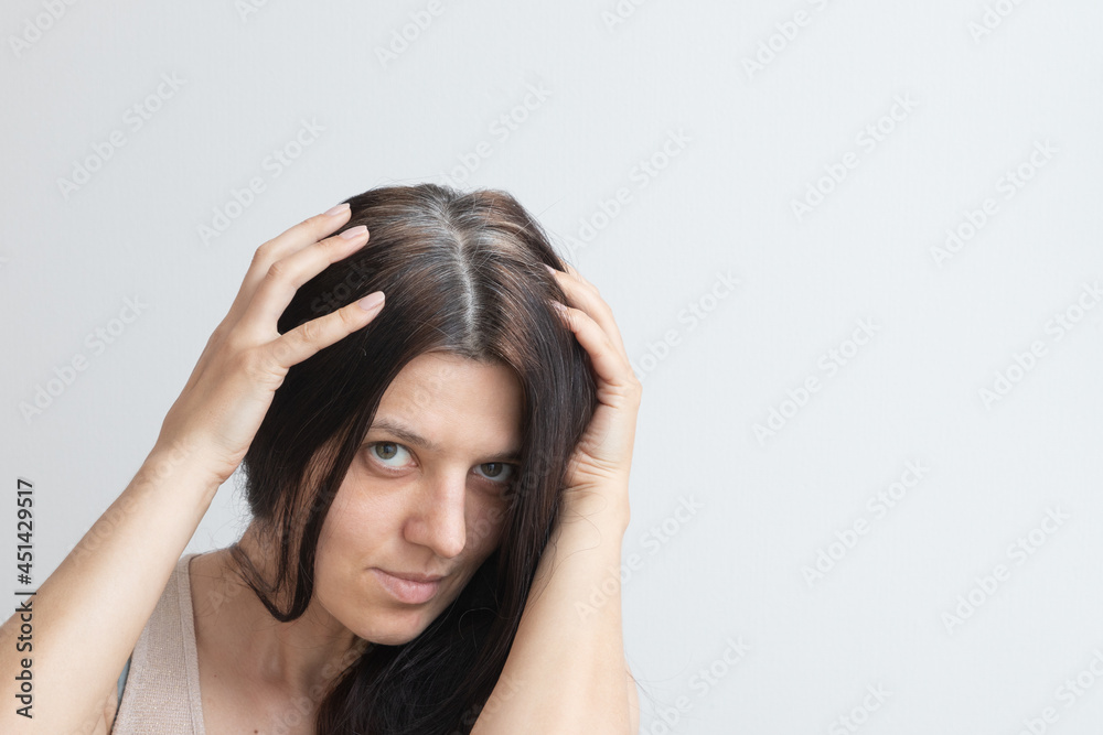 Fragments of gray hair on the head of a young woman. Early gray hair concept. Gray hair color and structure. Copy space Fragments of gray hair on the head of a young woman. Early gray hair concept. Gray hair color and structure. Copy space