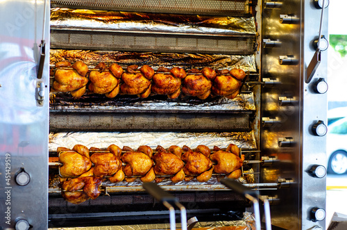 Roasted chickens on spit grilled over fire