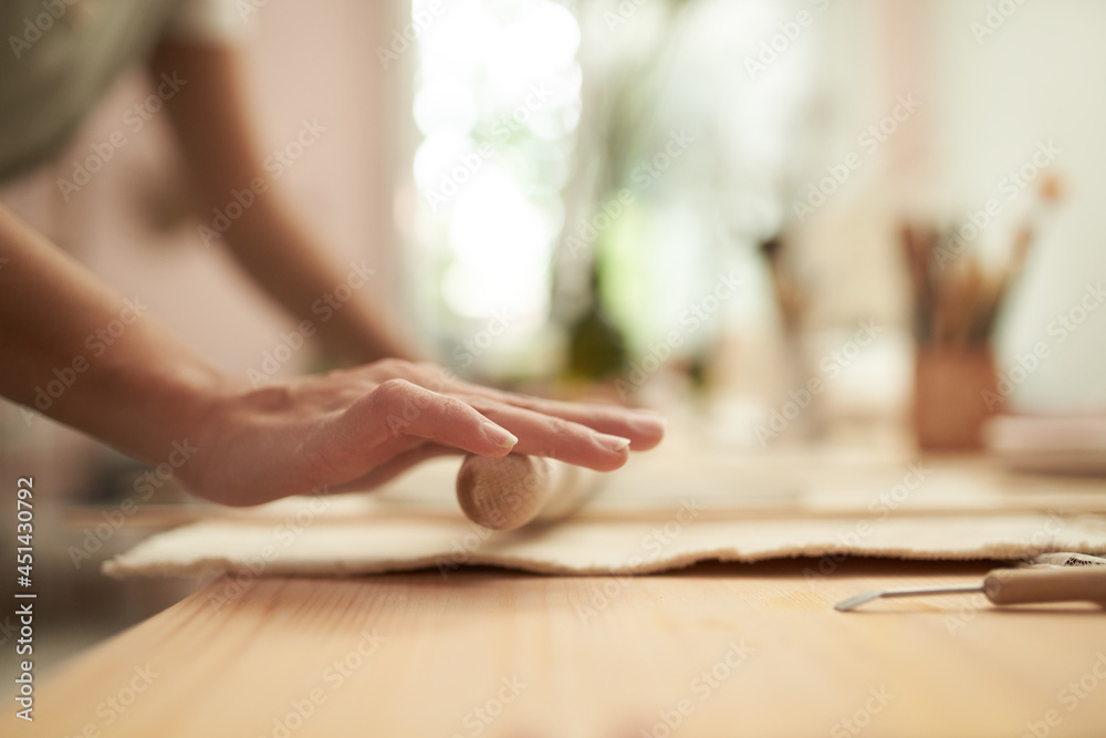 Obraz premium Ceramic master rolling clay on table