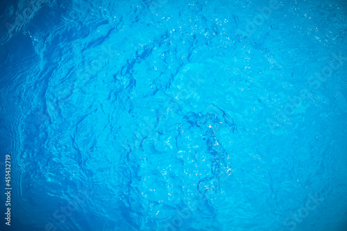 Water and air bubbles over blue background,sea wave ,Bokeh light background in the pool,Hotel swimming pool with sunny reflections.