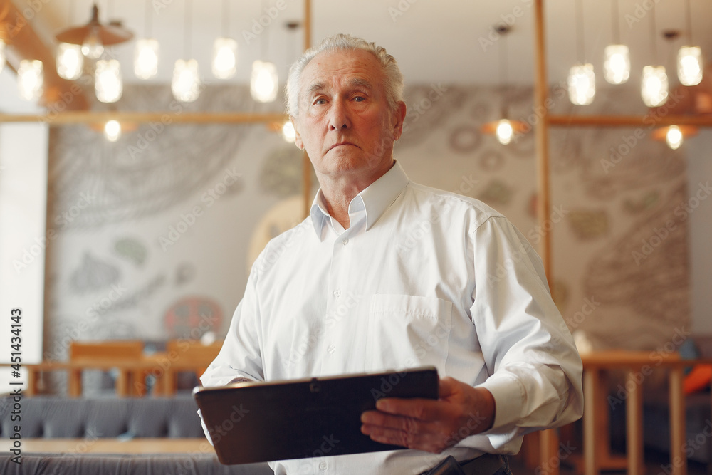 Elegant old man in a cafe using a laptop Elegant old man in a cafe using a laptop