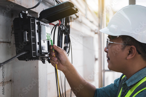 фотографія Engineer or technician checking fiber optic cables in internet splitter box