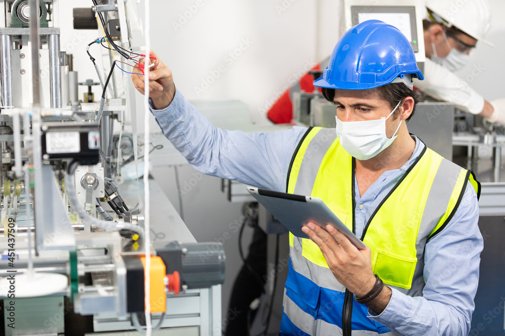 factory worker using tablet computer for finding how to fixing machine control panel in factory factory worker using tablet computer for finding how to fixing machine control panel in factory