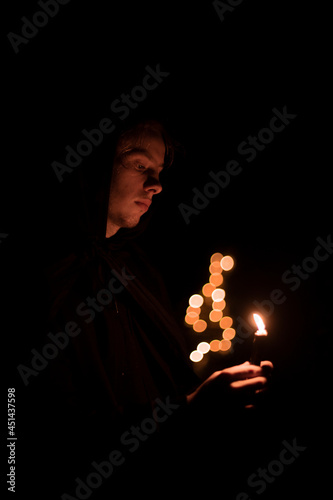 monk portrait human face hold candle fire light and pray in darkness environment space vertical photography soft focus concept