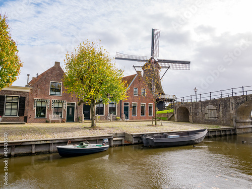 Windmill de Kaai, Heerenwal with houses and canal in Sloten, Sleat, Friesland, Netherlands photo