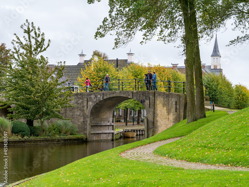 People walking on bridge of Woudsender water gate in fortified city Sloten, Sleat, Friesland, Netherlands