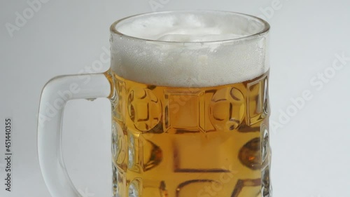 Beer with foam in a glass mug close up