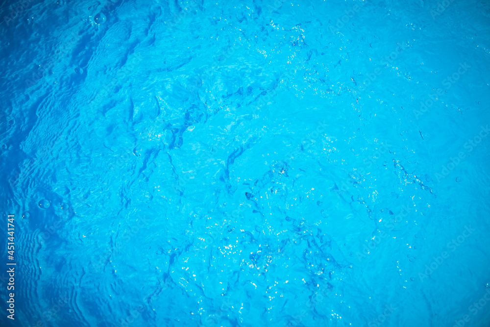 Water and air bubbles over blue background,sea wave ,Bokeh light background in the pool,Hotel swimming pool with sunny reflections. Water and air bubbles over blue background,sea wave ,Bokeh light background in the pool,Hotel swimming pool with sunny reflections.
