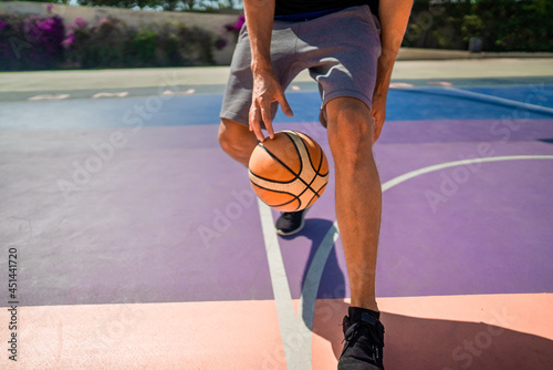 Legs of a professional basketball player dribbling the ball on the basketball field